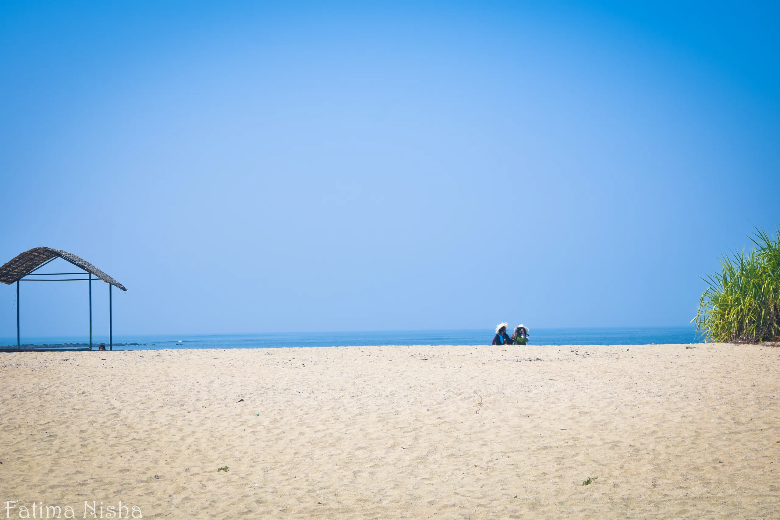 A quiet sandy beach with a thatched shelter on Chera Dwip