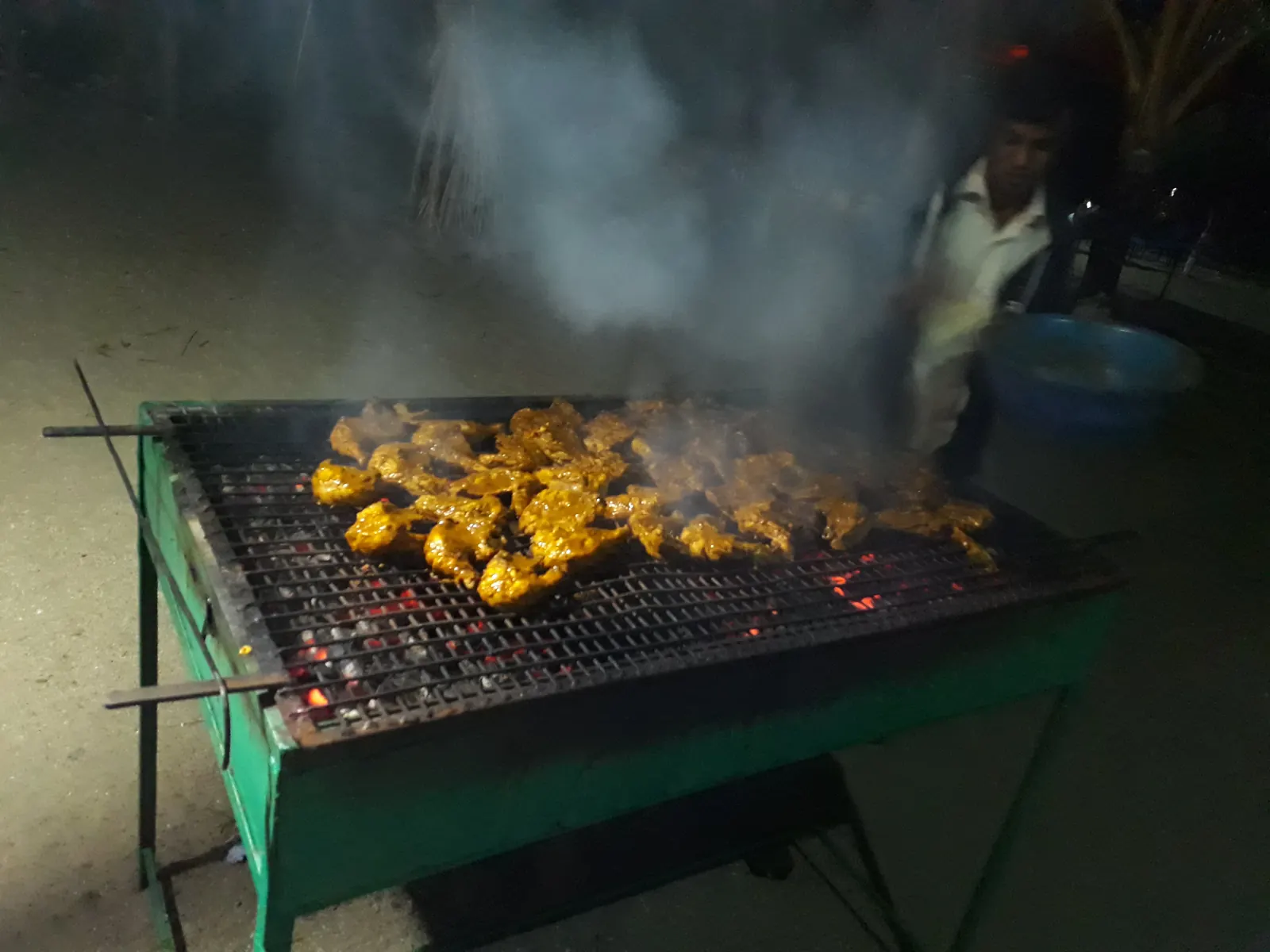 Chicken on an open charcoal grill in the evening